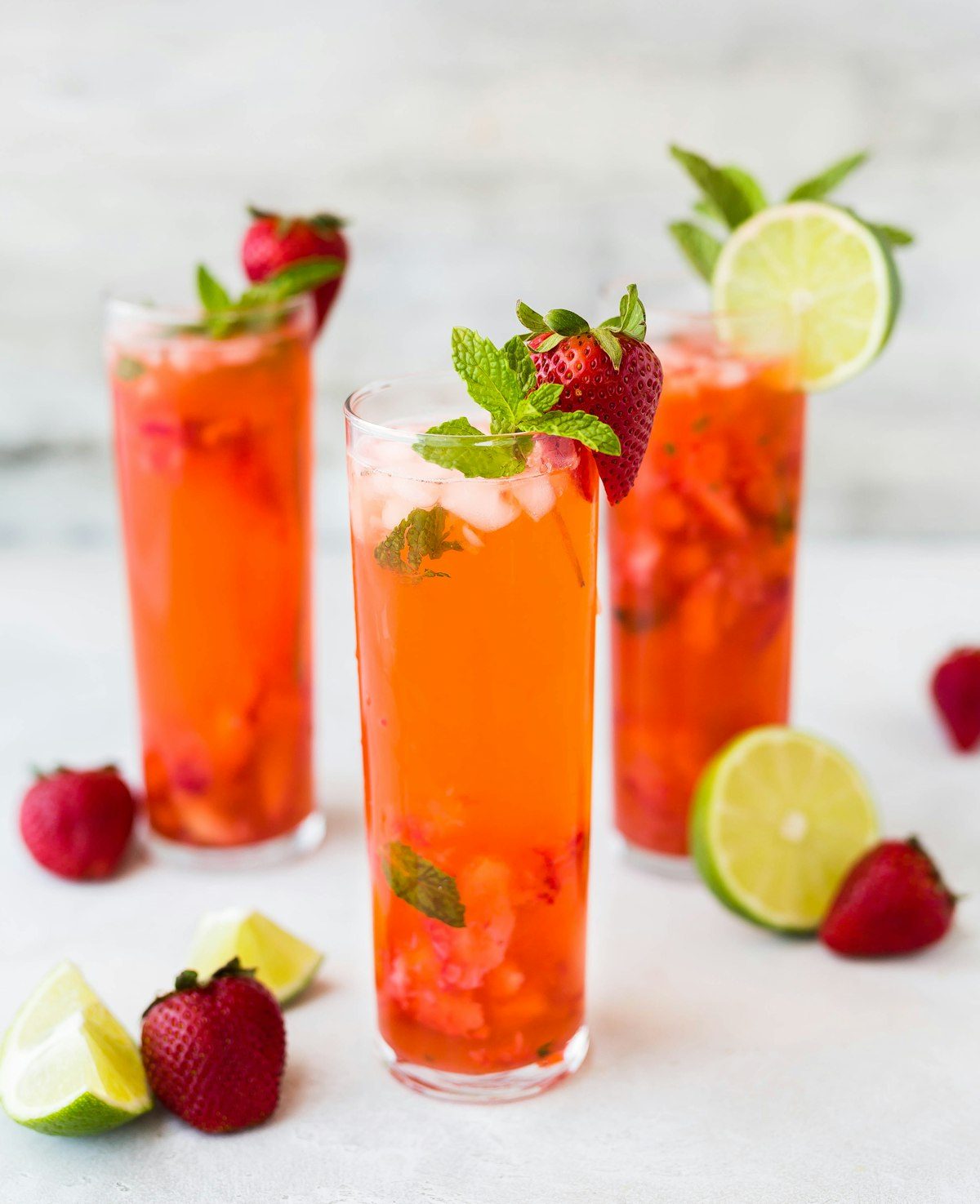 Drie fruitige sangria's met aardbeien, limoen en munt op een witte tafel