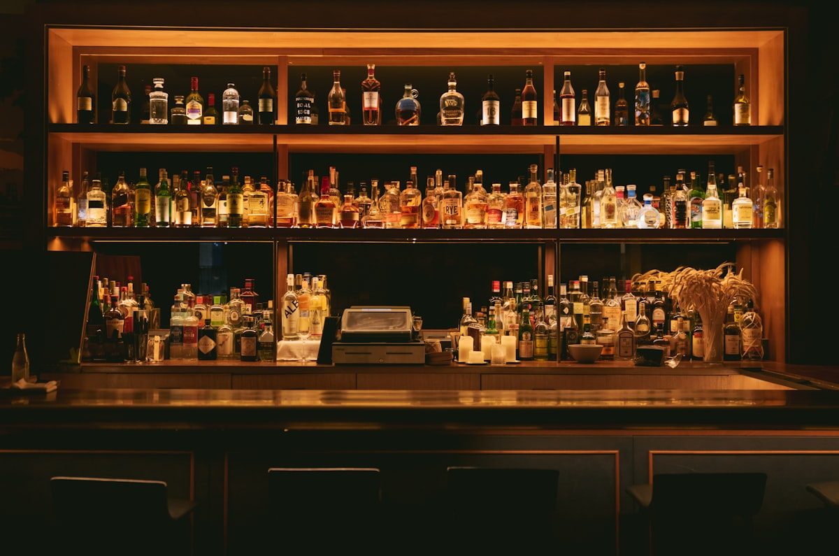 Whisky bar met vele flessen op verlichte planken